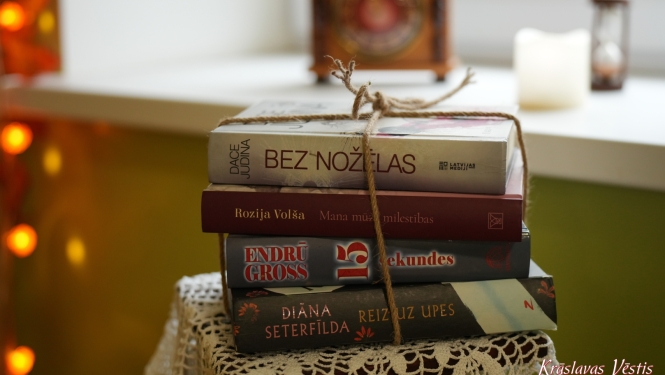 Kaudzē sasietas latviešu grāmatas uz tamborēta galdauta