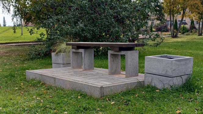 Āra soliņš ar galdu, kas ierīkots bruģētā atpūtas vietā pie ābeles