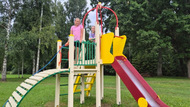 Bērni rotaļājas krāsainā rotaļu laukumā