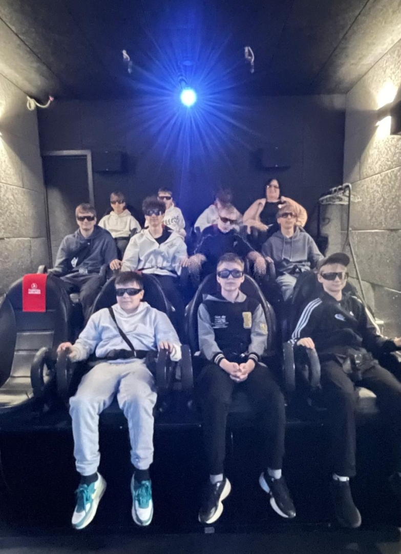 Skolēni sēž 5D kino zālē ar 3D brillēm