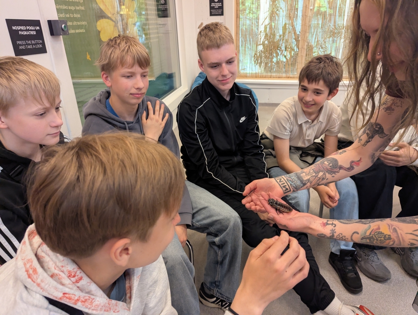 Skolēni aplūko kukaini nodarbības laikā