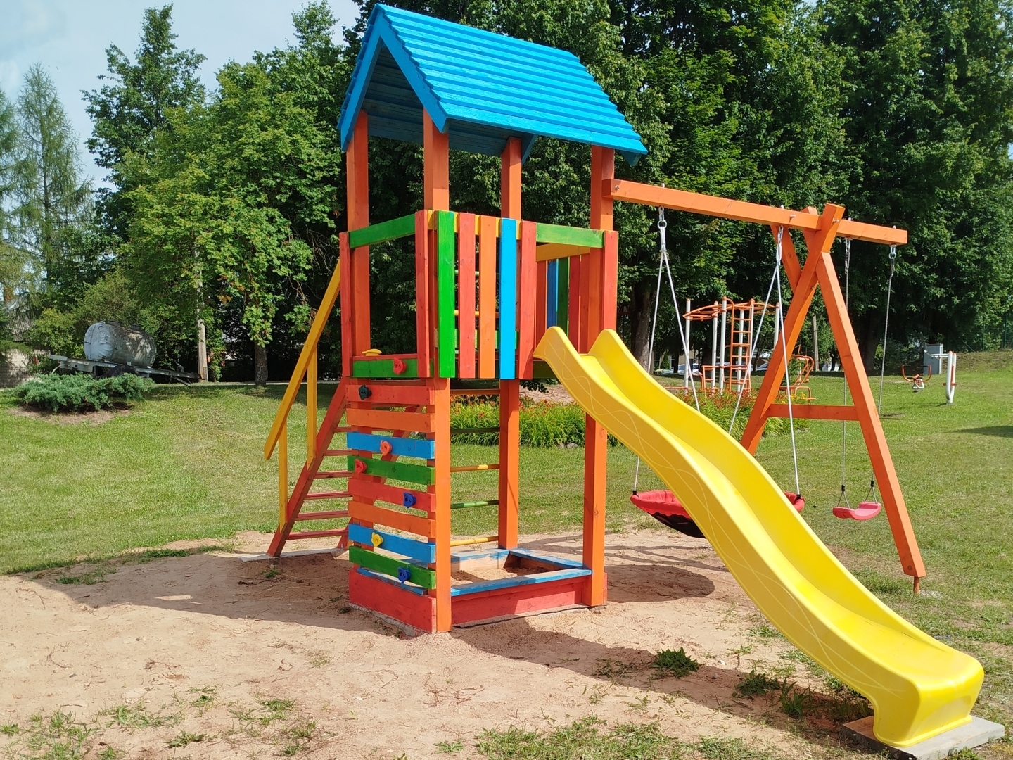 Krāsains bērnu rotaļu laukums ar slidkalniņu un šūpolēm