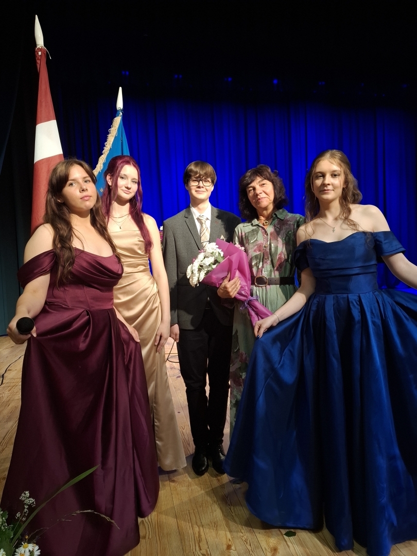 Pieci cilvēki uz skatuves pēc izlaiduma ceremonijas