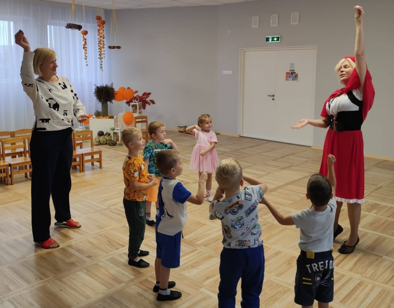 Skolotājas kopā ar bērniem izpilda kustību vingrinājumus