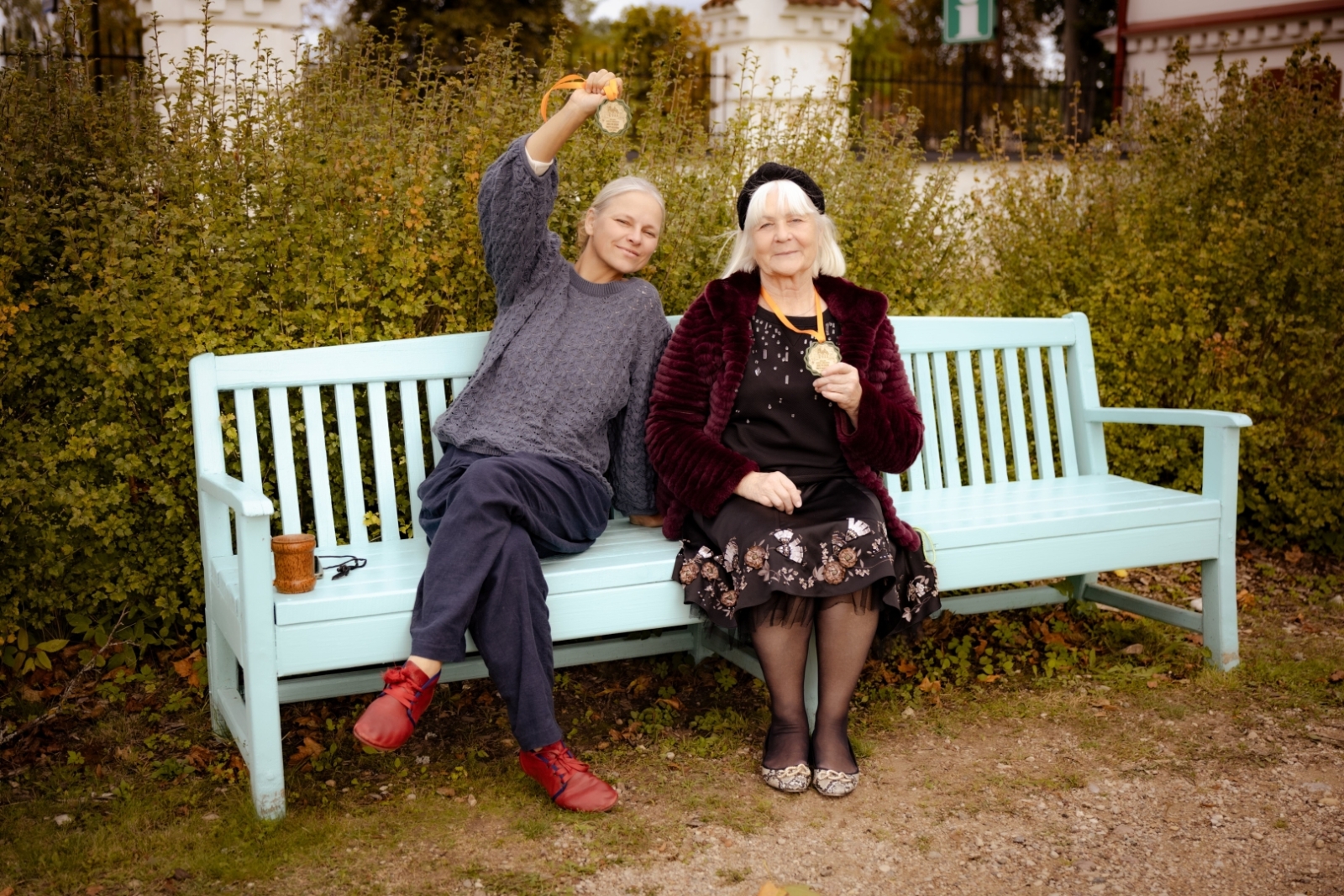 Divas sievietes ar medaļām uz soliņa