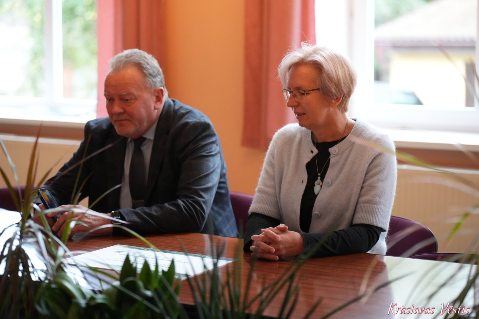 Divas personas pie galda pašvaldības telpās