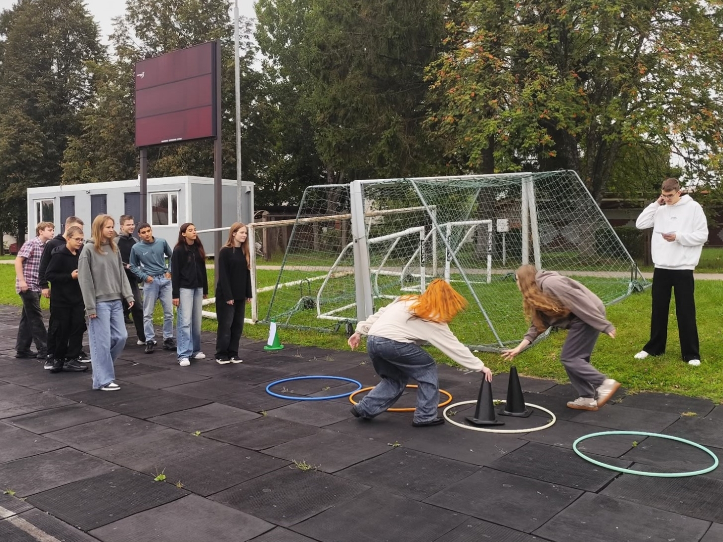 Jaunieši piedalās sportiskā aktivitātē skolas āra laukumā