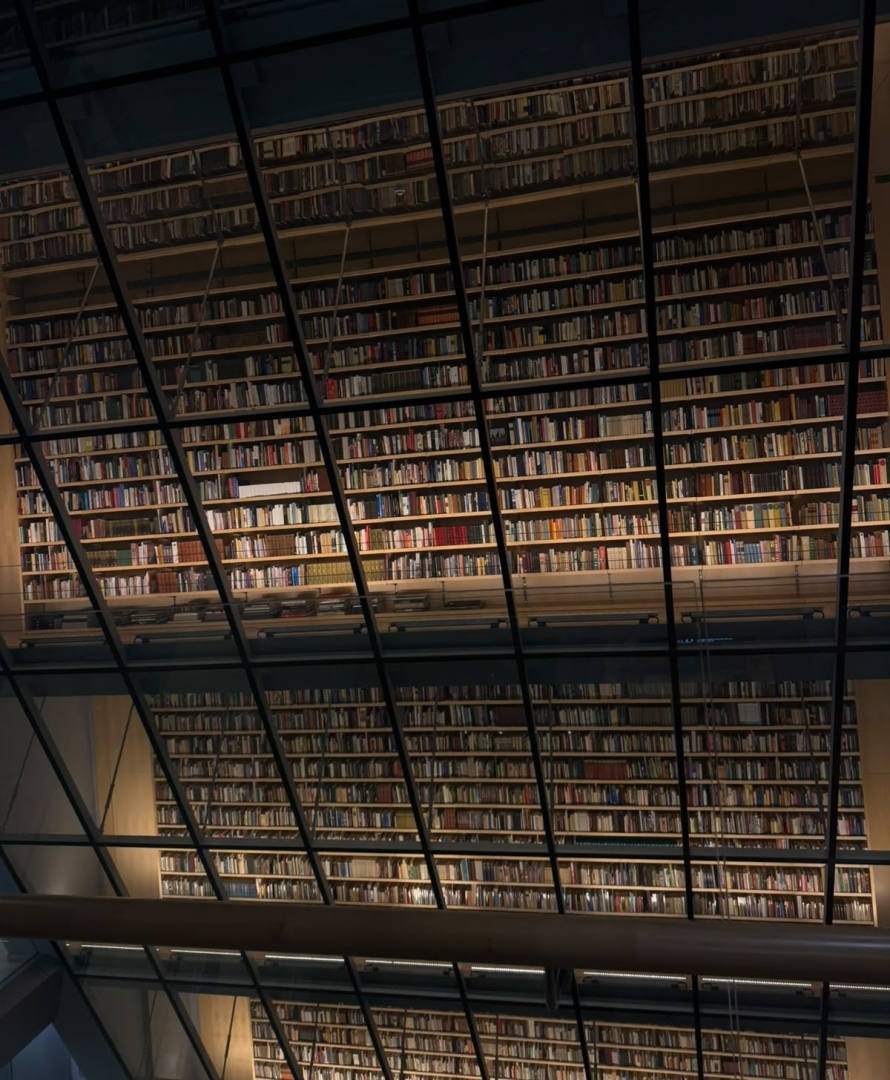 Bibliotēkas interjers ar augstiem grāmatu plauktiem