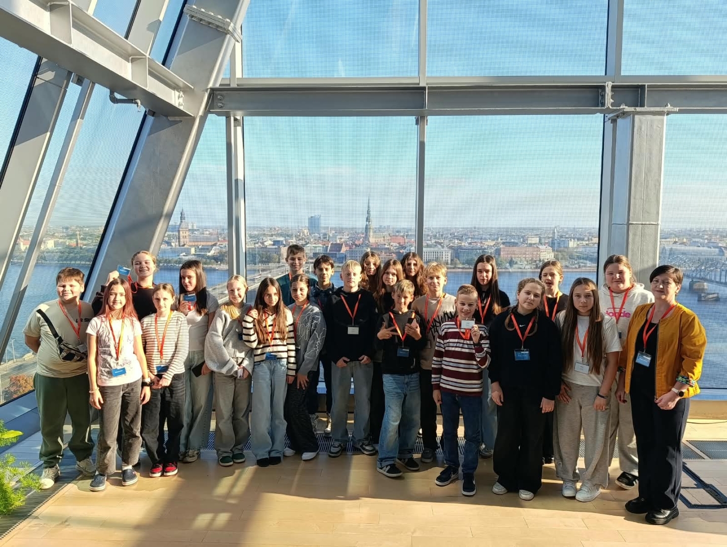 Skolēnu grupa uz Rīgas panorāmas fona