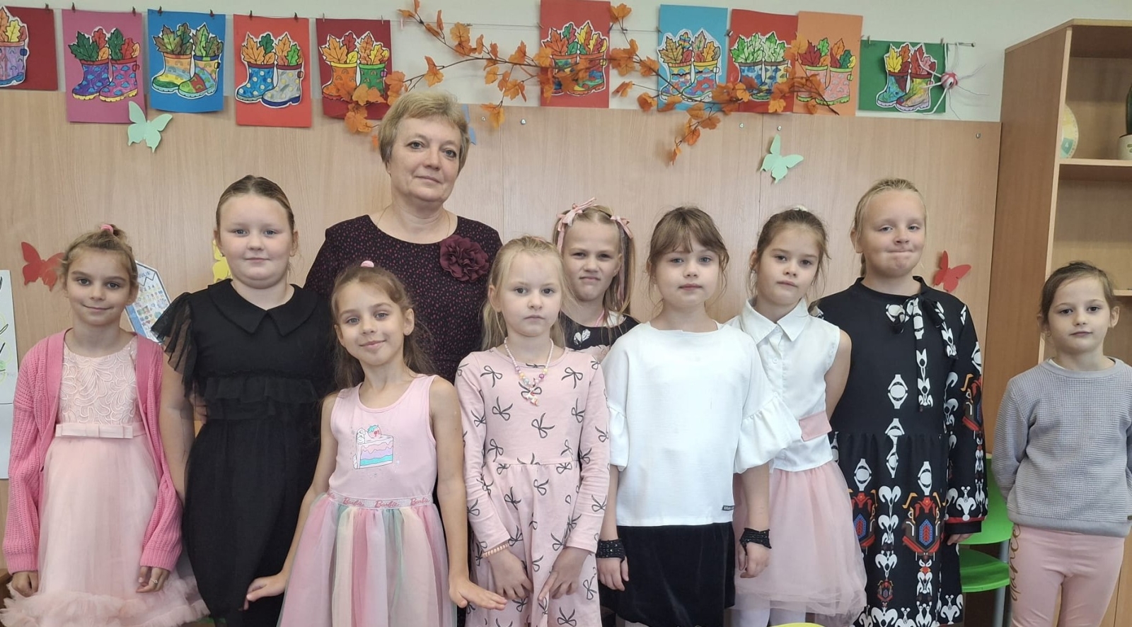 Skolotāja un skolnieces rudens dekorāciju priekšā