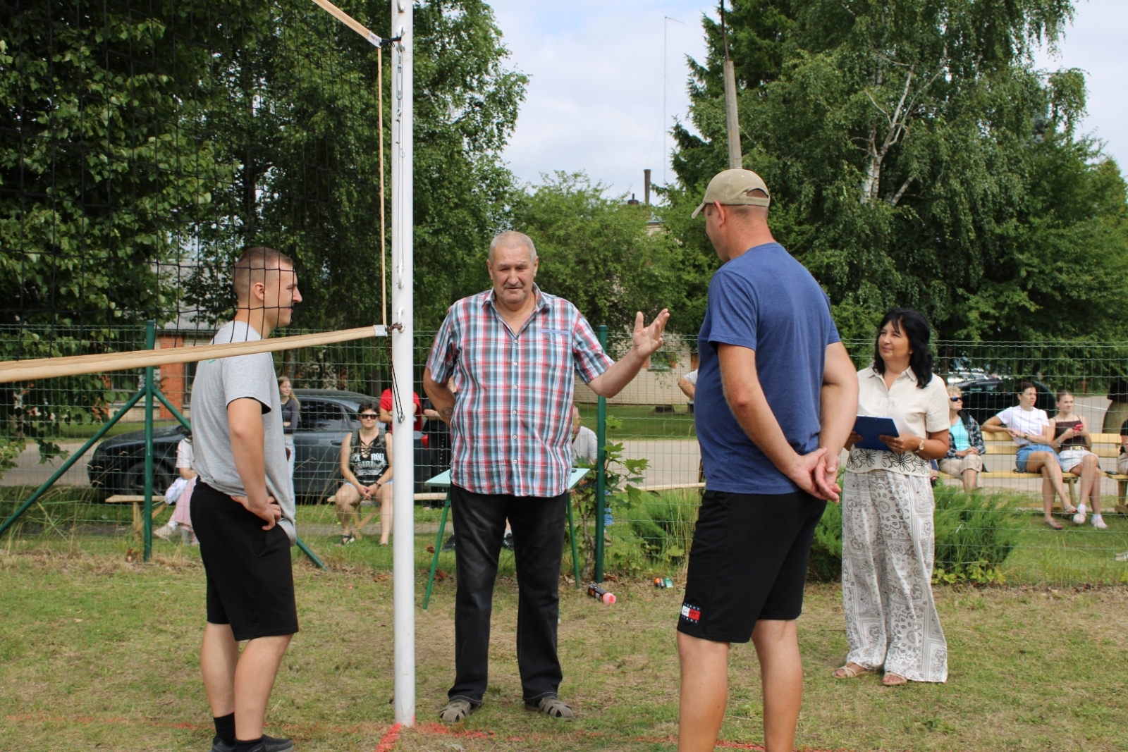 Turnīra organizatori un dalībnieki pie volejbola tīkla