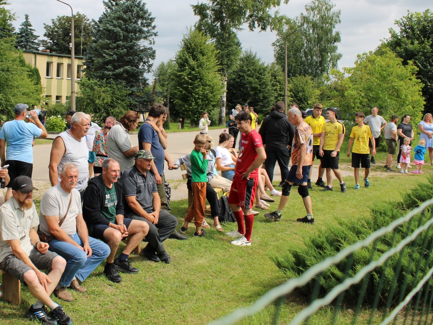 Skatītāji un sportisti pulcējas pie volejbola laukuma
