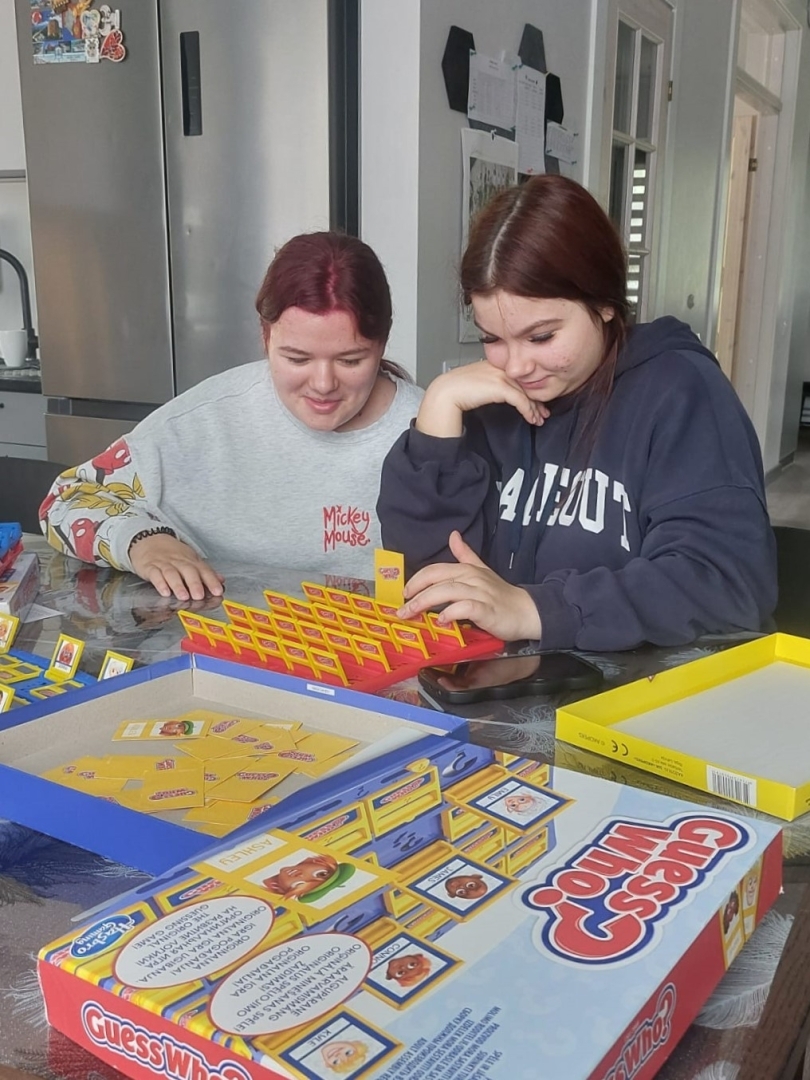 Divas jaunietes pie galda spēlē galda spēli