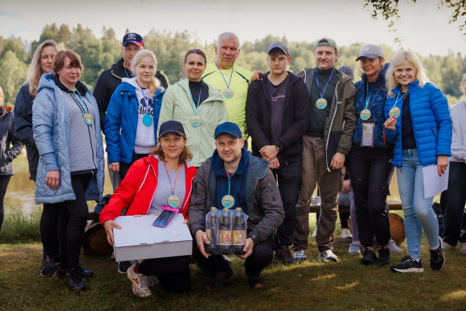 Priecīga komanda ar balvām un medaļām grupas foto