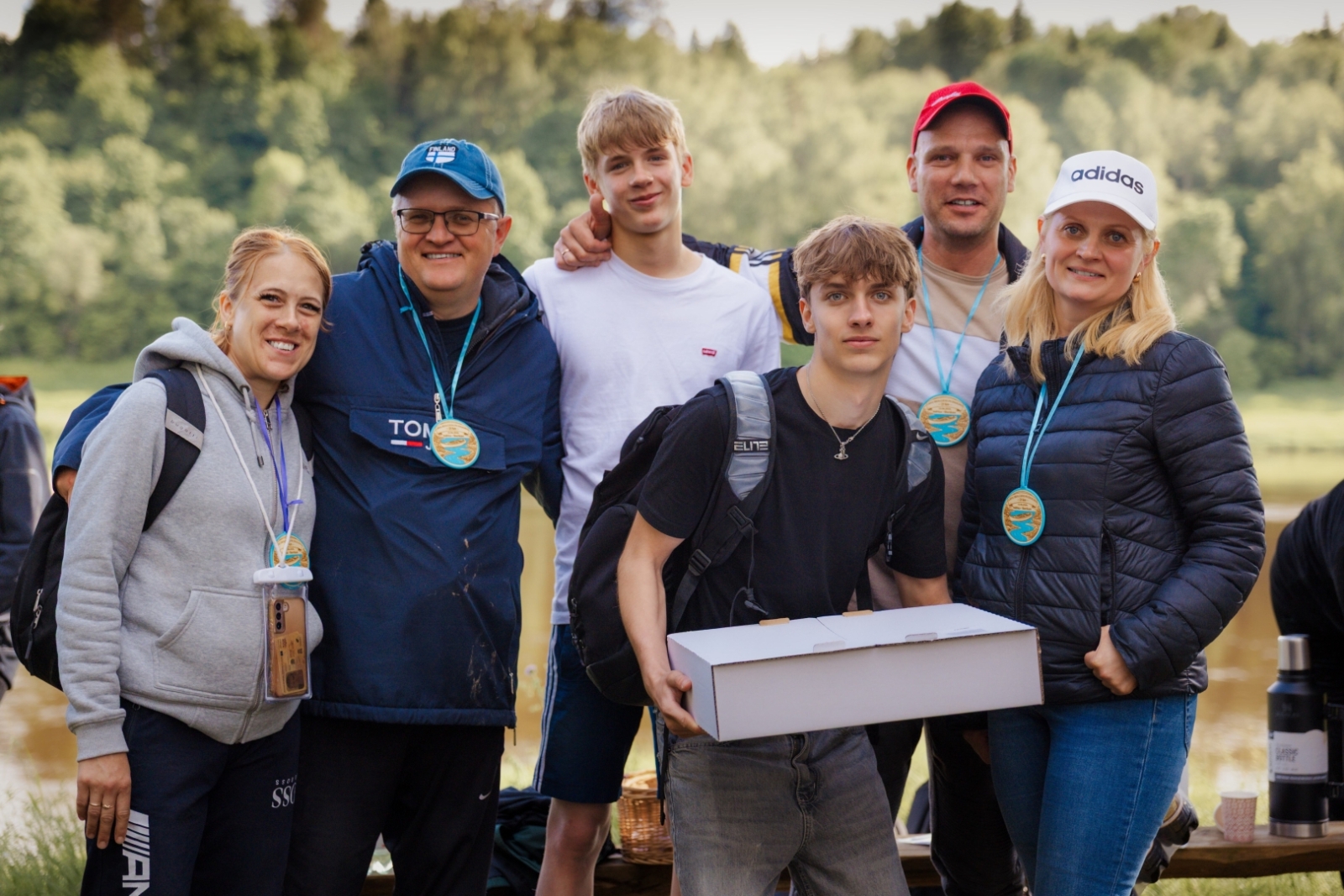 Priecīga komanda ar balvām un medaļām grupas foto