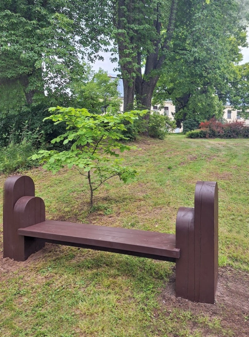 Koka sols parkā pie kokiem un apstādījumiem