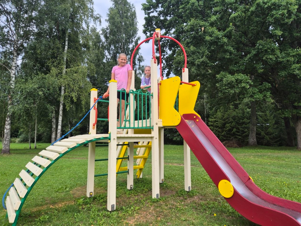 Bērni rotaļājas krāsainā rotaļu laukumā