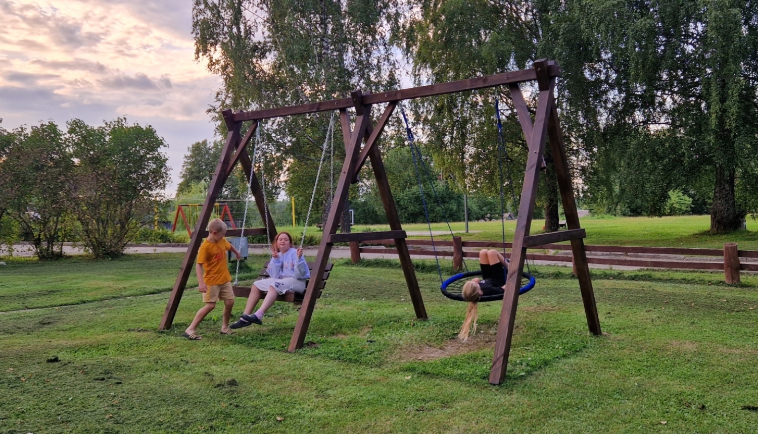 Bērni šūpojas koka šūpolēs