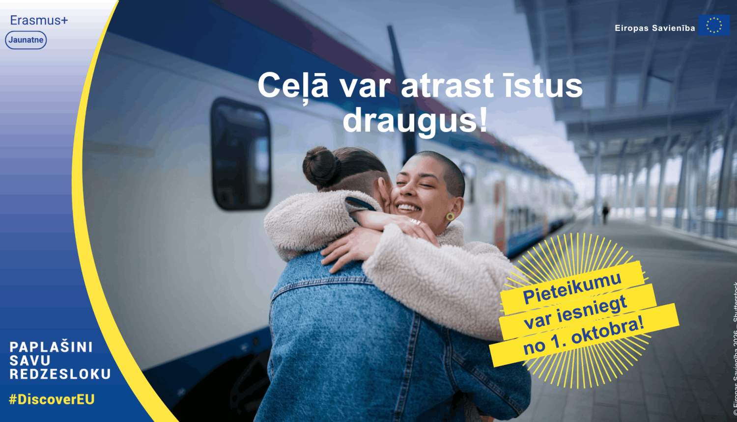Divi cilvēki apskaujas pie vilciena. Pasākuma vizuālis
