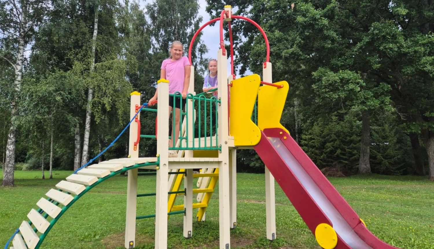 Bērni rotaļājas krāsainā rotaļu laukumā