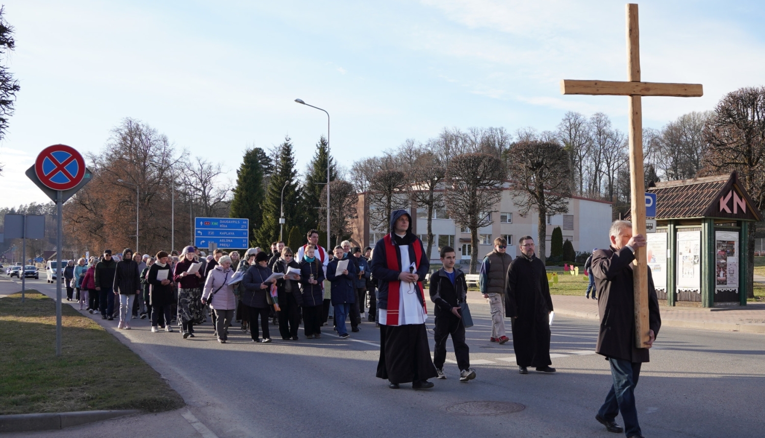 Cilvēki piedalās krusta ceļa gājienā pilsētas ielās