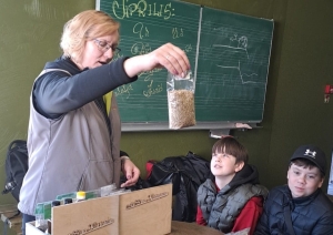 Skolotāja rāda skolēniem graudu paraugus
