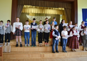 Skolēni lasa apsveikumus un dzejoļus pasākumā