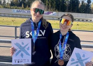 Divas rollerslēpotājas ar medaļām un diplomiem