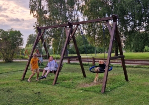 Bērni šūpojas koka šūpolēs