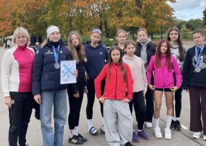 Rollerslēpotājas ar treneri rudens krāsās iekrāsotā parkā
