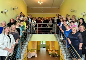 Liela cilvēku grupa pozē uz kāpnēm
