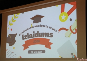 Uzraksts uz projektora ekrana “Krāslavas novada Sporta skolas Izlaidums 2026”