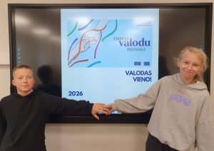Divi skolēni pie interaktīvās tāfeles demonstrē Eiropas Valodu festivāla materiālu