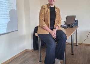 Skolotāja sēž klasē uz galda