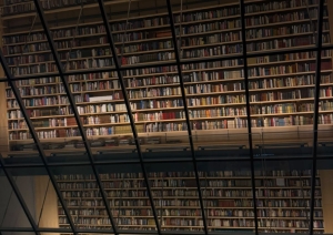 Bibliotēkas interjers ar augstiem grāmatu plauktiem