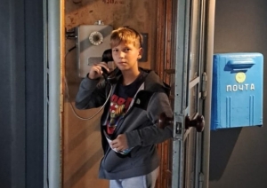 Skolēns izmēģina vēsturisku telefona būdiņu