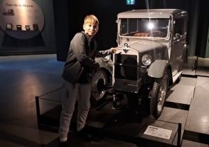 Skolēns pie vēsturiskas BMW automašīnas muzejā