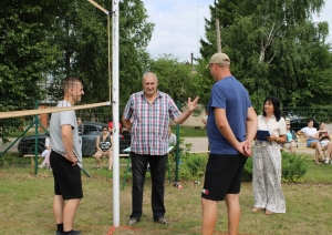 Turnīra organizatori un dalībnieki pie volejbola tīkla