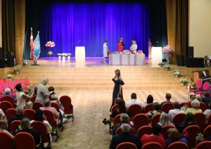 Izlaiduma ceremonija zālē ar skatītājiem un skatuvi