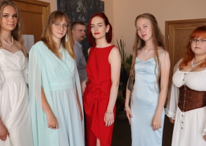 Piecas absolventes svinīgos tērpos pirms izlaiduma
