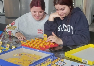 Divas jaunietes pie galda spēlē galda spēli