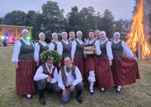 Dalībnieki tautastērpos pozē pie Jāņu ugunskura