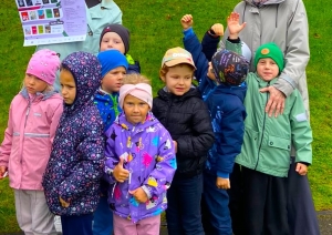 Bērni un pieaugušie ar lasīšanas akcijas plakātu