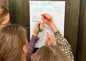 Jaunieši pie durvīm raksta atbildes uz plakāta