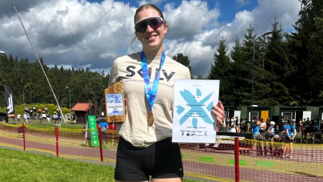 Adriāna ar medaļu, kausu un diplomu