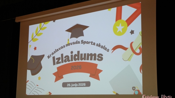 Uzraksts uz projektora ekrana “Krāslavas novada Sporta skolas Izlaidums 2026”