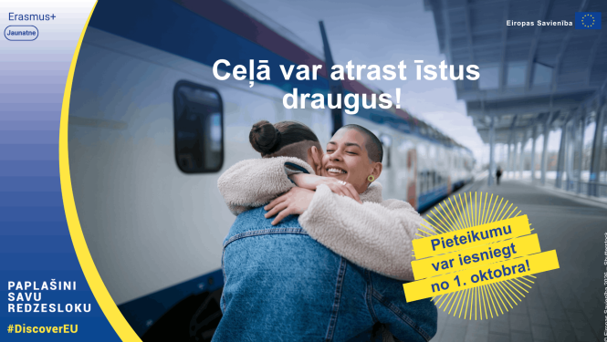 Divi cilvēki apskaujas pie vilciena. Pasākuma vizuālis
